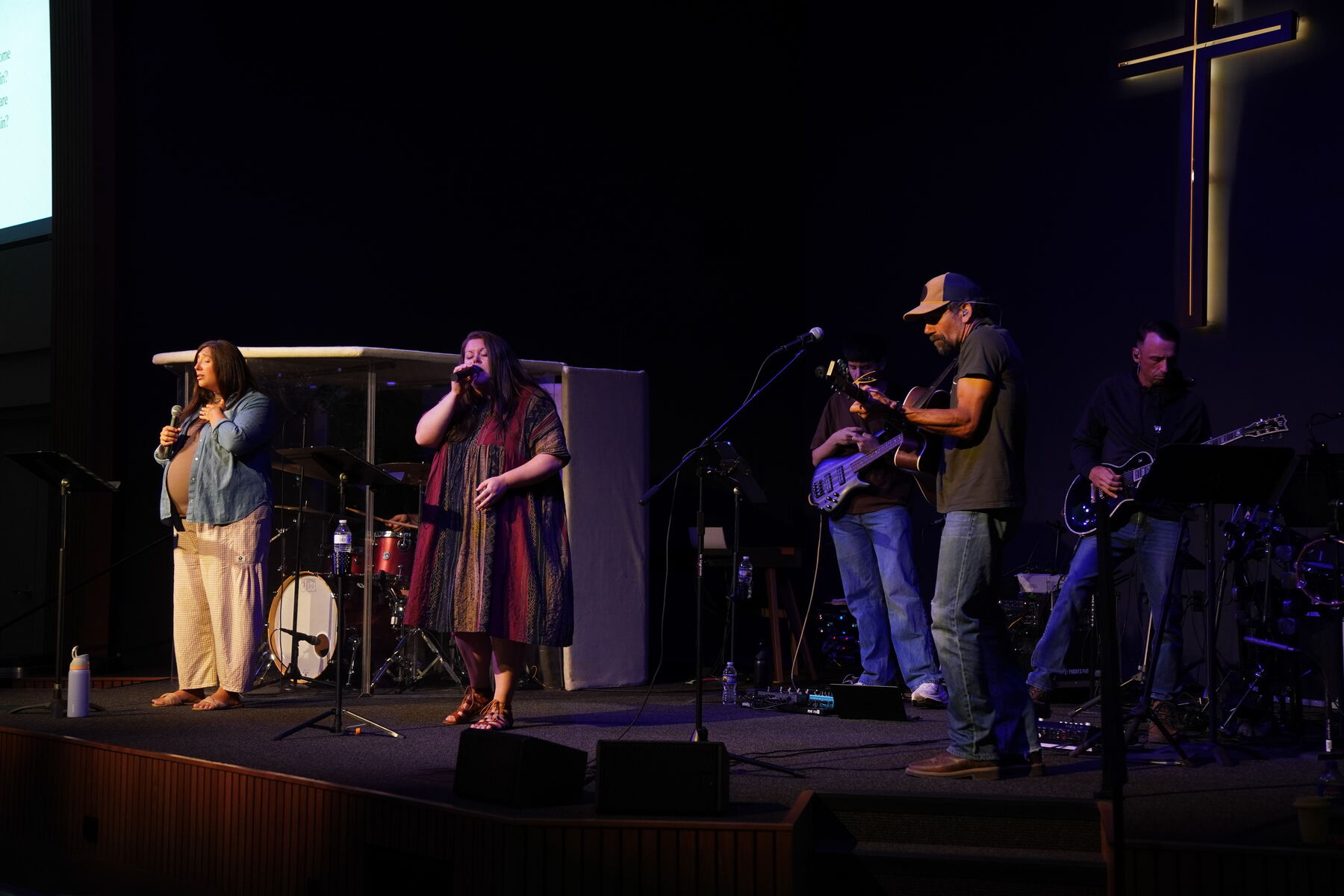 Vocalists leading worship with hands raised