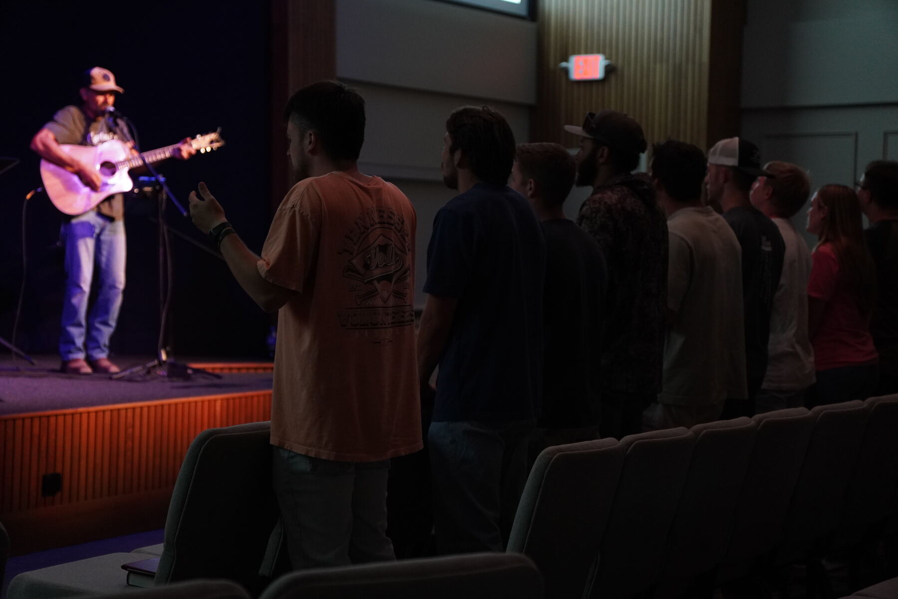 A group of guys worshipping at the back of the room